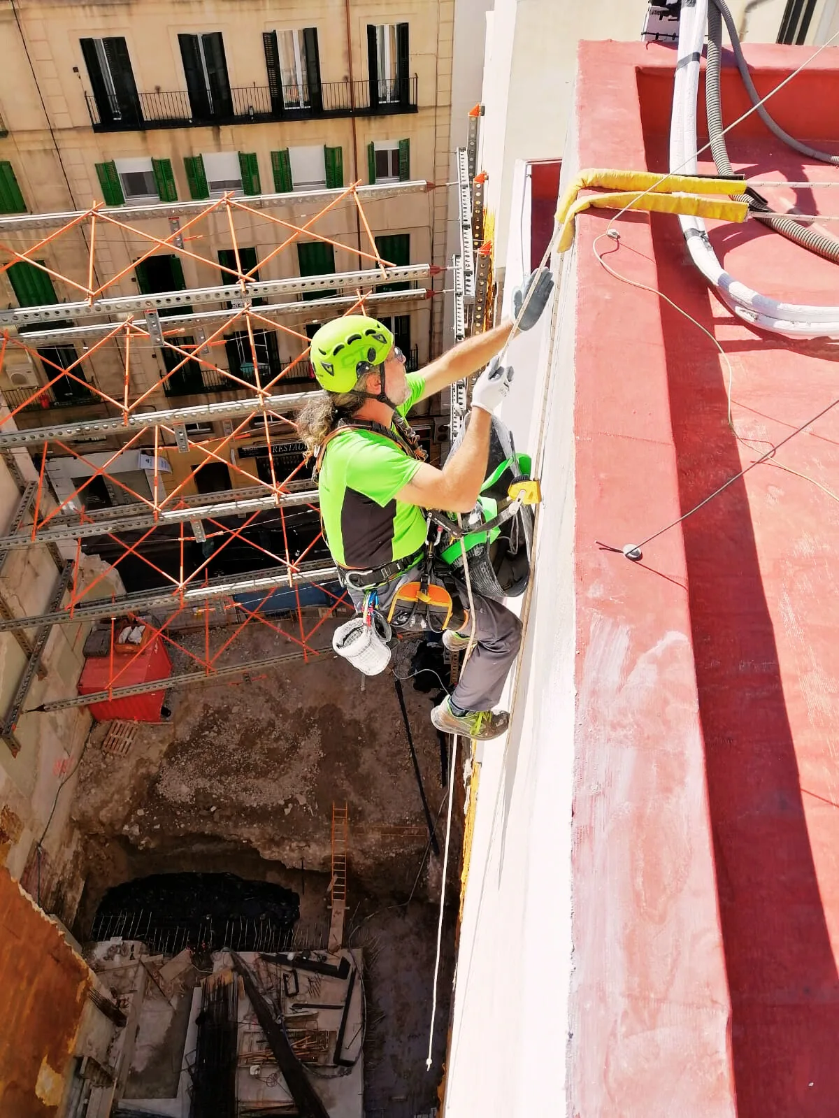 Operario de trabajo vertical con epis en inspección técnica de fachada