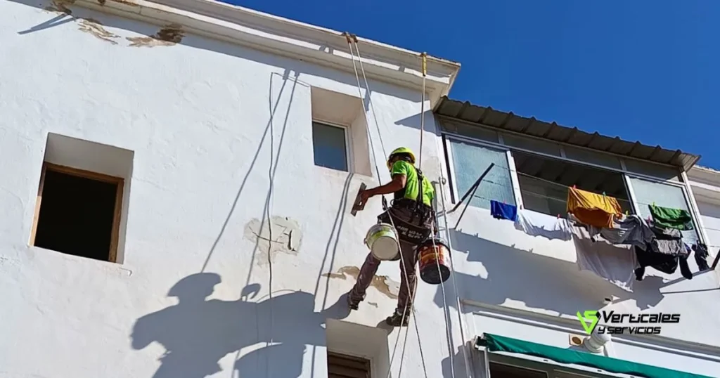 Trabajador de Verticalesyservicios reparando una fachada.